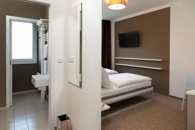 a bedroom with a bed and a sink and a mirror at Skyhotel Prague in Prague
