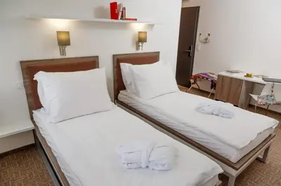 two beds in a room with white sheets and pillows at Skyhotel Prague in Prague