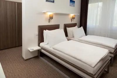 two beds in a room with white sheets and pillows at Skyhotel Prague in Prague