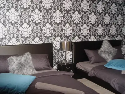 a bedroom with two beds and a damask wallpaper at Neklanova Apartments in Prague