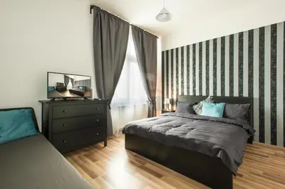 a bedroom with a bed and a dresser and a window at Neklanova Apartments in Prague
