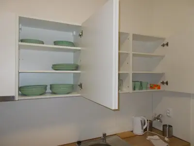 a kitchen with white cabinets with green dishes in it at Neklanova Apartments in Prague