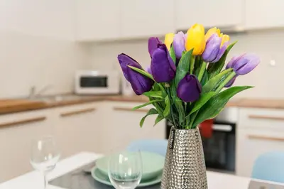 a vase filled with purple and yellow flowers on a table at Neklanova Apartments in Prague