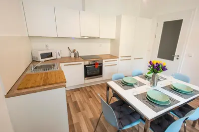 a kitchen with white cabinets and a table with chairs at Neklanova Apartments in Prague