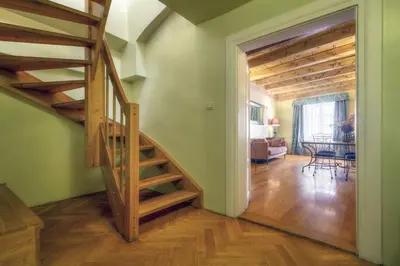 a hallway with a staircase and a living room at Black Star Suites in Prague