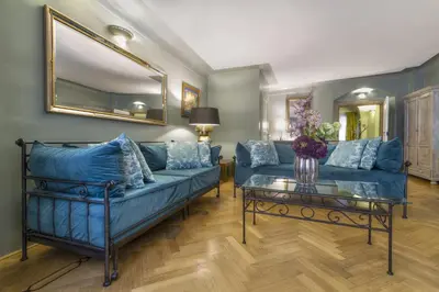 a living room with a blue couch and a table at Black Star Suites in Prague