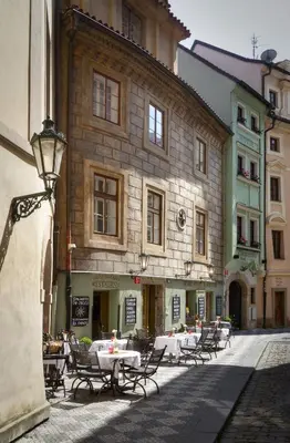 a group of tables and chairs in front of a building at Black Star Suites in Prague