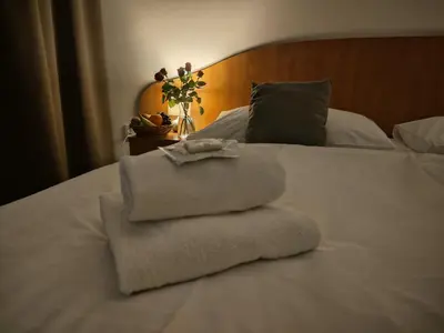 a pile of towels sitting on top of a bed at Hotel Legie in Prague