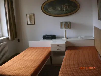 a room with two beds and a table with a lamp at pension Kalik in Prague