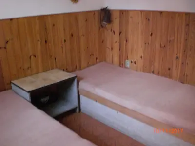 a room with two beds with wooden walls at pension Kalik in Prague