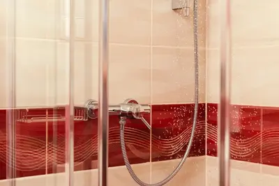 a shower with a hose in a bathroom at Ostende Chocerady - ubytování u řeky in Chocerady
