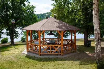 a wooden gazebo with a table in a park at Resort Beach Nová Živohošť in Křečovice