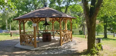 a wooden gazebo with a table in a park at Resort Beach Nová Živohošť in Křečovice