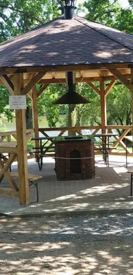 a wooden gazebo with a grill in a park at Resort Beach Nová Živohošť in Křečovice