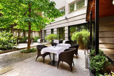 a restaurant with white tables and chairs in front of a building at Hotel Prokop Square in Prague