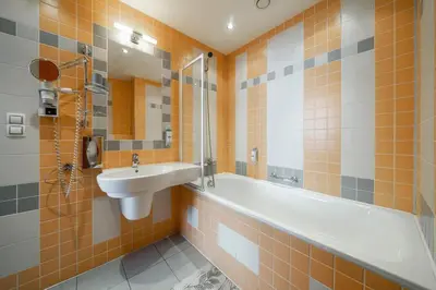 a bathroom with a sink and a bath tub and a sink at Penzion Homer Poděbrady in Poděbrady