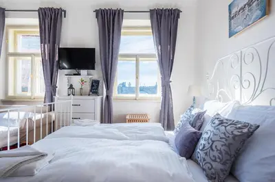 a bedroom with a large white bed and a window at Charles Apartment in Prague