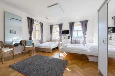 a white kitchen with white cabinets and a sink at Charles Apartment in Prague