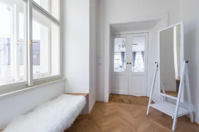 a white room with a staircase and a window at Charles Apartment in Prague