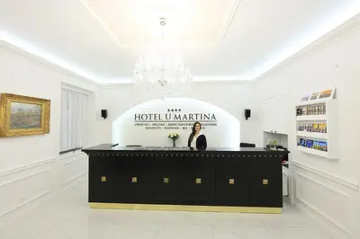 a woman standing behind a podium in a white room at Martin Hotel Prague in Prague