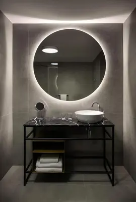 a bathroom with a sink and a round mirror at MOODs Charles Bridge in Prague