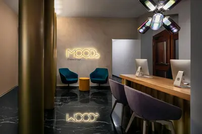 a lobby with chairs and a bar with a sign on the wall at MOODs Charles Bridge in Prague