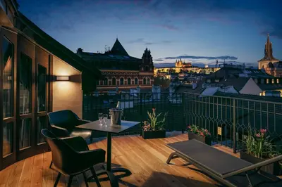 a balcony with a table and chairs and a city skyline at MOODs Charles Bridge in Prague