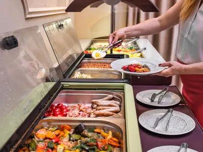 a woman is preparing food in a buffet at Maestro by Adrez in Prague