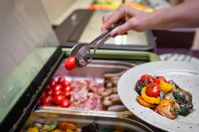 a person holding a utensil over a plate of food at Maestro by Adrez in Prague