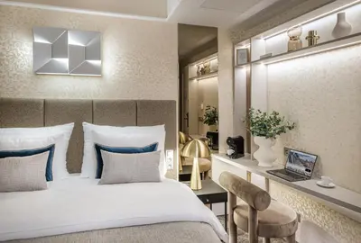 a bedroom with a bed and a desk with a laptop at Maestro by Adrez in Prague