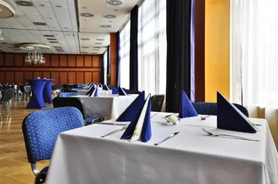 a row of tables with laptops on them in a restaurant at Hotel Olympik in Prague