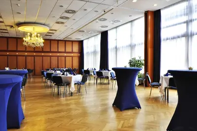 a dining room with tables and chairs and a chandelier at Hotel Olympik in Prague