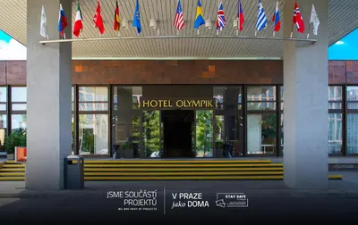 a hotel entrance with flags in front of a building at Hotel Olympik in Prague