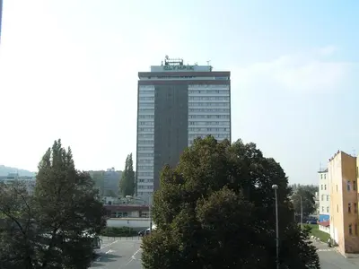 a tall building in the middle of a city at Hotel Olympik in Prague