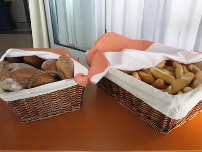 two baskets filled with different types of bread on a table at Olympik Tristar in Prague