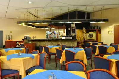 a restaurant with blue and yellow tables and chairs at Olympik Tristar in Prague