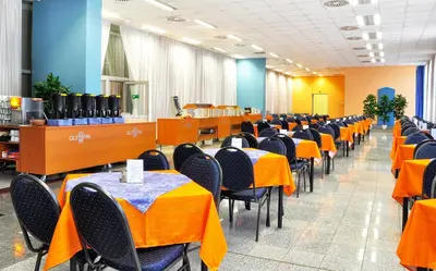 a dining room with orange tables and chairs at Olympik Tristar in Prague