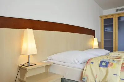 a bedroom with a bed and a table with a lamp at Olympik Artemis in Prague