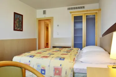 a bedroom with a bed and a table with a lamp at Olympik Artemis in Prague