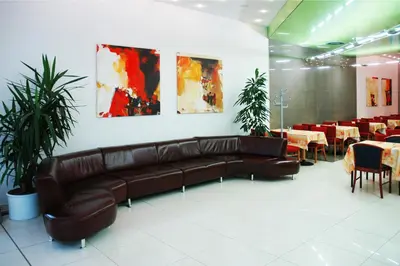 a brown leather couch in a restaurant with tables and chairs at Olympik Artemis in Prague