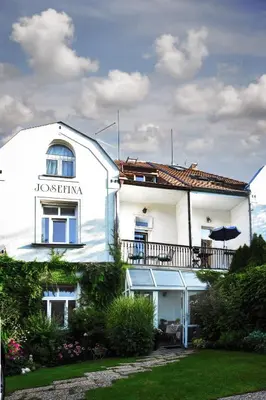 a white building with a sign on the side of it at Vila Josefina in Prague