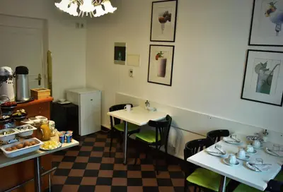 a dining room with two tables and a checkered floor at Vila Josefina in Prague