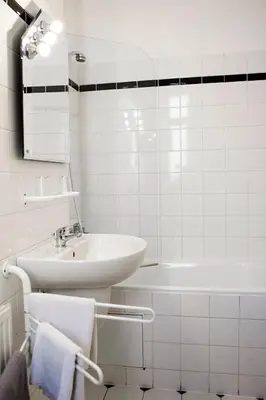 a white bathroom with a sink and a tub at Vila Josefina in Prague