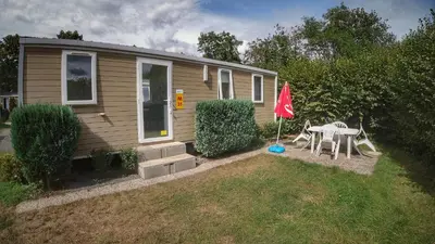 a small house with a table and a flag at Camping Sokol Praha in Prague