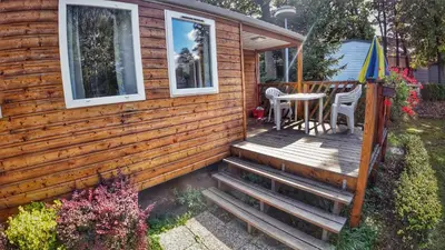 a wooden cabin with stairs leading to a deck at Camping Sokol Praha in Prague
