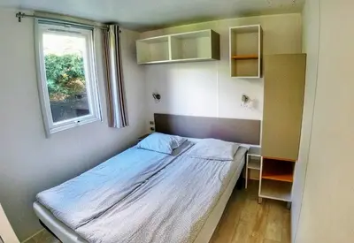 a small bedroom with a bed and a window at Camping Sokol Praha in Prague