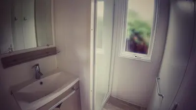 a white bathroom with a sink and a mirror at Camping Sokol Praha in Prague
