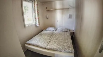 a small bed in a small room with a window at Camping Sokol Praha in Prague