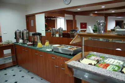 a restaurant with a counter with food on it at Alexis in Prague