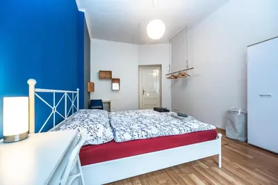 a bedroom with a bed and a blue wall at Vltava Apartments Prague 7 in Prague